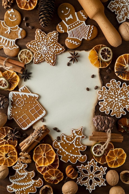 Biscoitos de gengibre de Natal Natureza morta em uma mesa com um rolo de massa cravo secos cítricos pinhões e cones canela noz e papel kraft