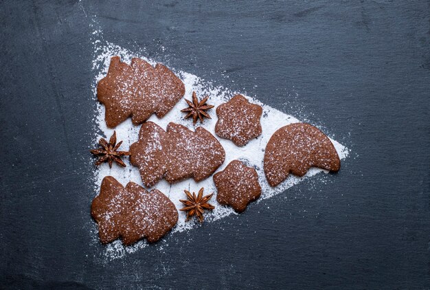 Biscoitos de gengibre e açúcar de confeiteiro em ardesia em forma de árvore de Natal