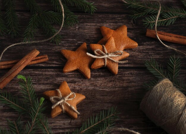 Biscoitos de gengibre em forma de estrelas com ramos de canela e abeto