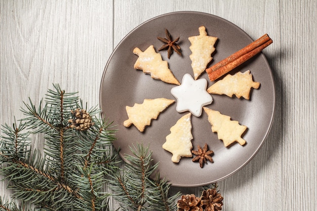 Biscoitos de gengibre na árvore de Natal e forma de estrela no prato