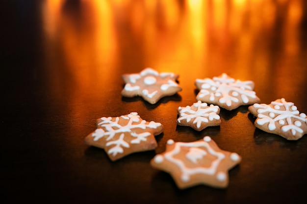 Biscoitos de gengibre na mesa marrom escura e fundo com bokeh dourado