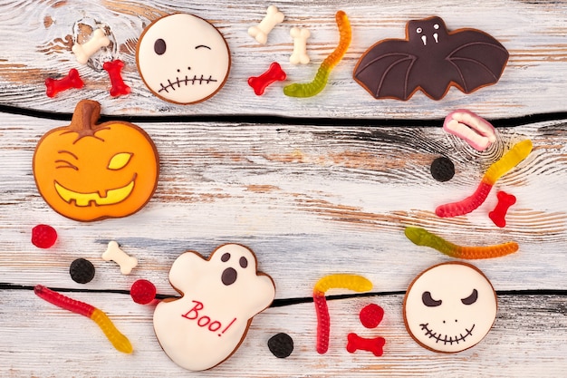 Biscoitos de Halloween e doces em fundo de madeira.