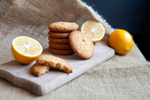 Biscoitos de limão e gengibre estão sobre uma tábua de madeira sobre uma mesa rústica