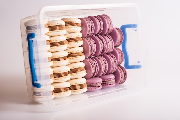 Biscoitos de macarons rosa e brancos na caixa Isolados em fundo branco Sobremesa saborosa