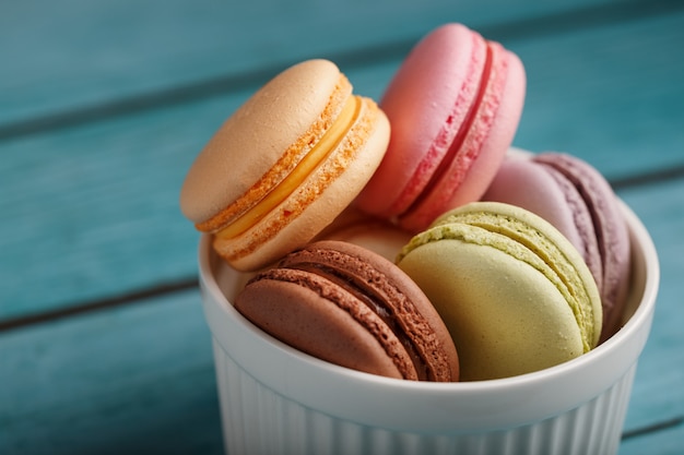 Biscoitos de macarrão são colocados em um prato branco sobre um fundo azul de madeira.