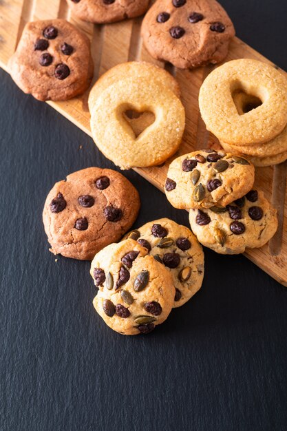 Biscoitos de manteiga de açúcar caseiro de conceito de comida na placa de madeira na placa de pedra ardósia preta com espaço de cópia