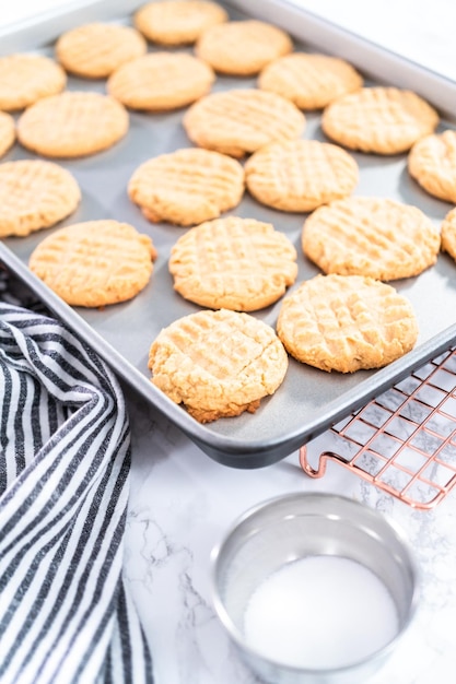 Foto biscoitos de manteiga de amendoim recém-assados em uma assadeira.