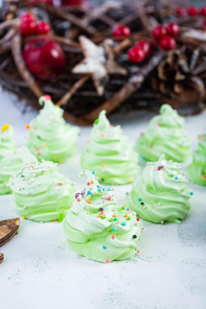 Biscoitos de merengue com decoração de Natal. Sobremesa francesa. Árvore de natal de merengue