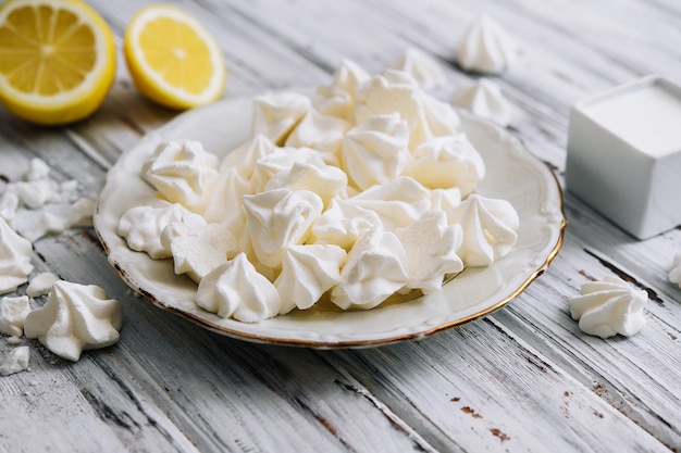 Biscoitos de merengue em um prato na madeira