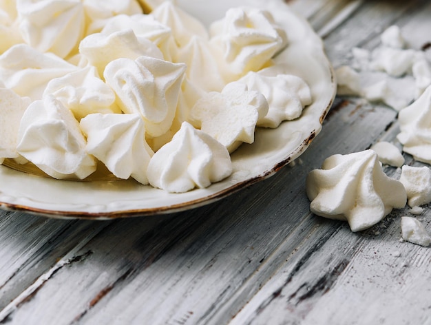 Biscoitos de merengue em um prato na madeira