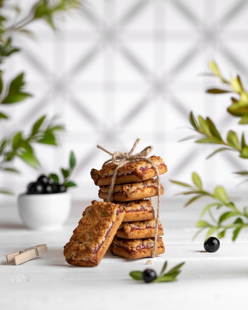 Foto biscoitos de mirtilo amarrados com barbante uma mesa branca perto da janela