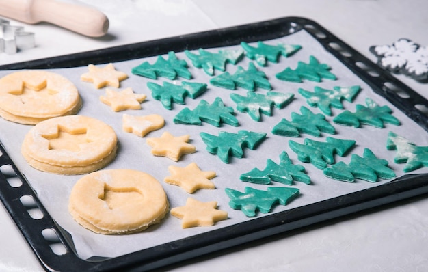 Biscoitos de natal antes de assar em uma assadeira O conceito de preparação para a celebração