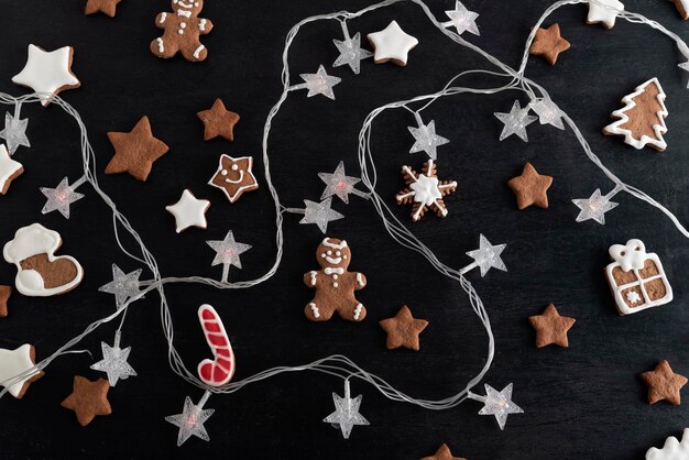 Biscoitos de Natal cobertura de açúcar vitrificada e Garland em Gingerbreads de fundo preto