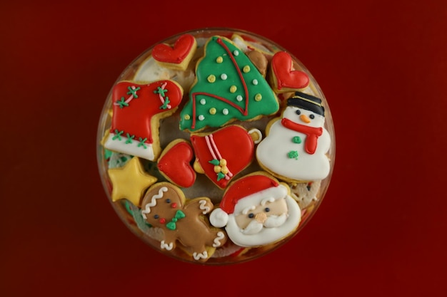 Biscoitos de natal com decoração de glacê real com fundo vermelho