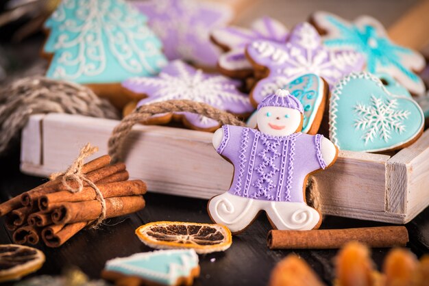 Biscoitos de Natal de gengibre, flocos de neve um homem-gengibre. Cachecol de malha e paus de canela.