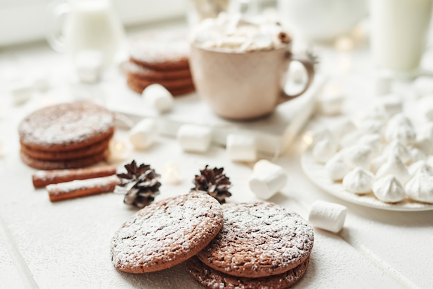 Biscoitos de natal e marshmallows em um branco perto da janela