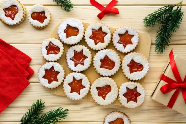 Biscoitos de Natal em forma de estrelas e sinos com geleia na madeira