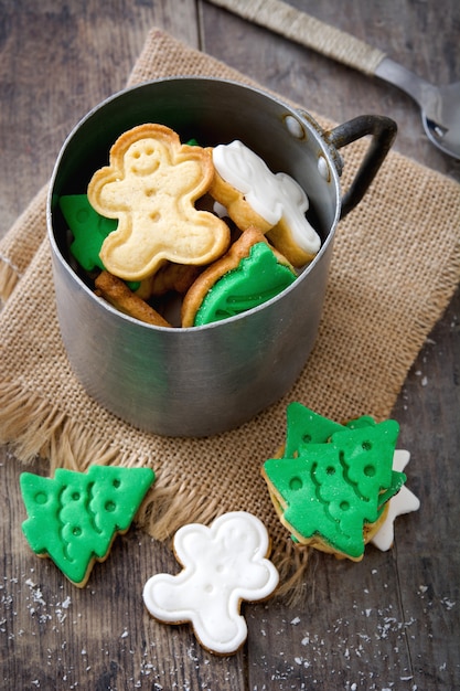 Foto biscoitos de natal em um copo de metal na mesa de madeira