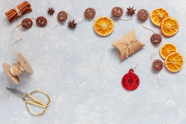 Biscoitos de Natal, especiarias, fatias de laranja secas no fundo cinza de concreto