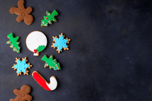 Biscoitos de Natal sortidos em forma de árvore de Natal Gingerbread man Snowflake candy can no fundo escuro