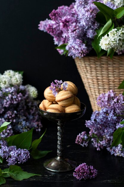 Biscoitos de nozes com leite condensado em copo vintage muitas flores lilás ao redor