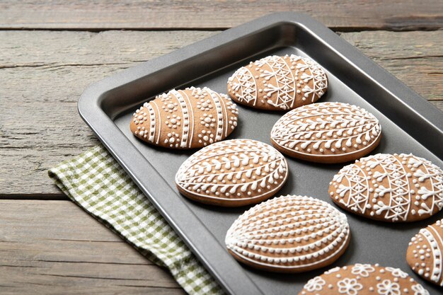 Biscoitos de Páscoa em uma assadeira sobre uma superfície de madeira velha. Ovos de pascoa.