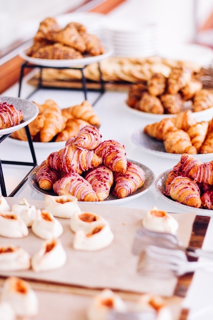 Biscoitos de pastelaria e croissants sobremesas doces servidas em bebidas alimentares de evento de caridade e conceito de menu a ...