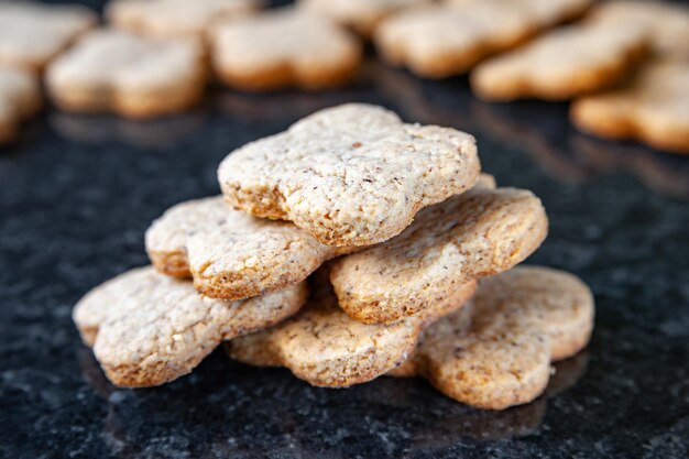 Biscoitos de pilha de nozes. Muitos biscoitos de nozes estão em uma mesa de mármore escura. Comida caseira.