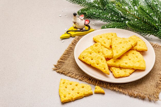 Biscoitos de queijo festivo, conceito de lanche do ano novo. Biscoitos, figura de rato, galho de árvore do abeto, neve artificial, guardanapo de pano de saco.