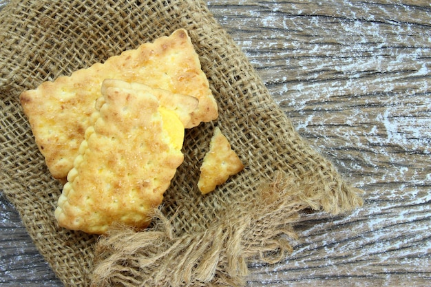 Biscoitos de sanduíche com creme acima do saco na mesa de madeira