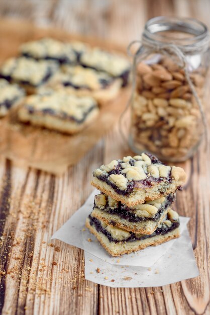 Biscoitos de Shortbread com geléia de mirtilo no papel manteiga no fundo de madeira.