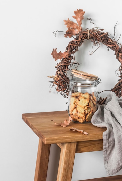 Biscoitos de shortbread em uma coroa de videira de decoração de outono em uma mesa de madeira sobre um fundo leve