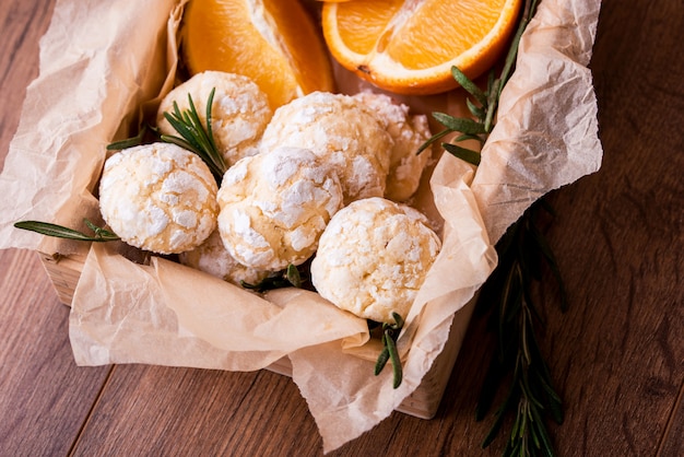 Biscoitos de shortbread laranja com raminhos de gergelim, com laranja fresca e suco em cima da mesa.