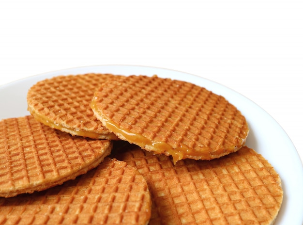 Biscoitos de Stroopwafel, doces tradicionais holandeses, servidos na chapa branca, isolada no fundo branco