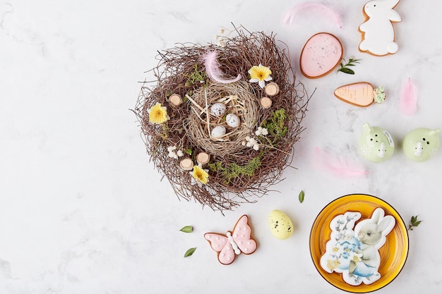 Biscoitos decorados com vidros de Páscoa entre decorações de ninhos de penas na mesa