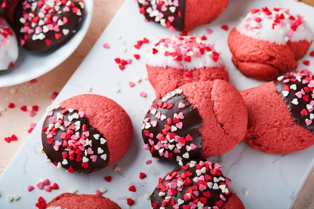 Biscoitos do dia dos namorados Biscoitos amanteigados com cobertura de chocolate branco e escuro e granulado de coração no prato fundo rosa Dia das mães Dia da mulher Feriado doce assando Vista superior