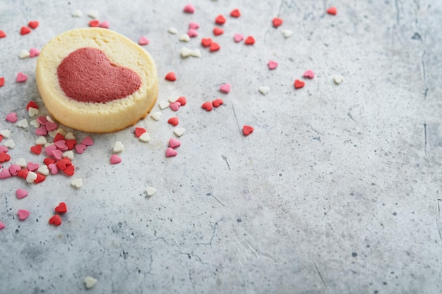 Biscoitos do dia dos namorados Biscoitos amanteigados dentro de um doce coração vermelho no prato rosa no fundo cinza Dia das mães Dia da mulher Feriados doces assando Vista superior