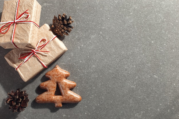 Biscoitos do pão-de-espécie do Natal na forma de uma árvore de Natal e de presentes em uma pedra, copyspace do ofício.