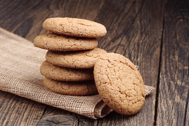 Biscoitos doces de aveia em um guardanapo de um tecido áspero na mesa de madeira