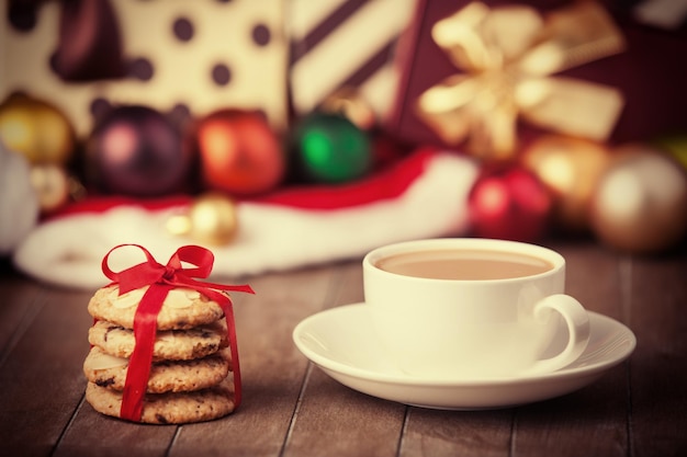 Biscoitos e café com presentes de natal ao fundo