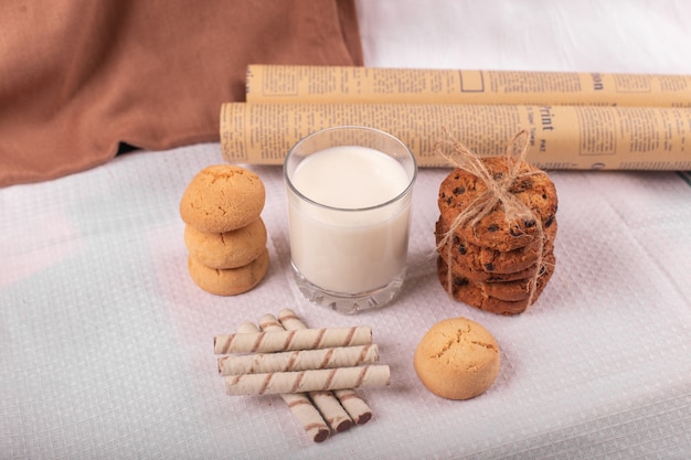 Biscoitos e um copo de leite em uma mesa branca