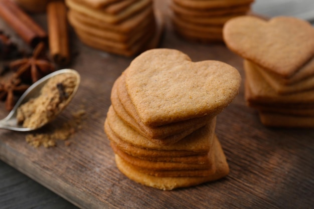 Biscoitos em forma de coração e canela na tábua de cortar