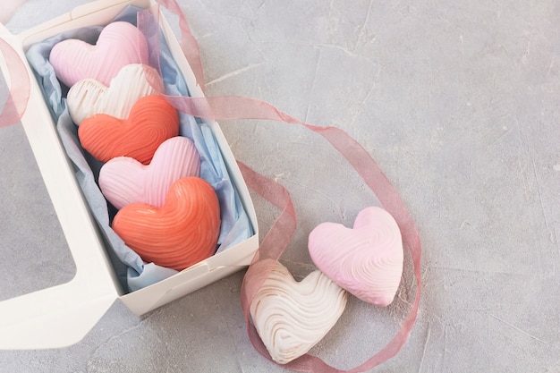 Biscoitos em forma de coração em uma caixa de presente com fita.