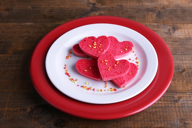 Biscoitos em forma de coração no prato sobre fundo de pranchas de madeira rústica