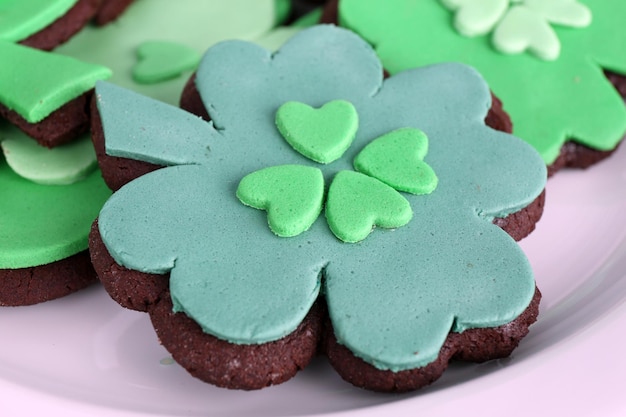 Biscoitos em forma de quatro folhas de trevo para St Patrick Day no prato fecham