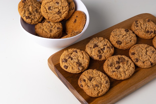 biscoitos em uma tábua e uma tigela branca sobre a mesa