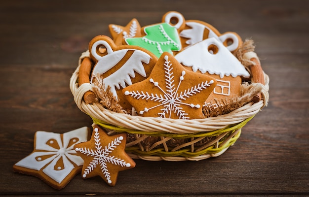 Biscoitos festivos de gengibre de Natal em forma de uma estrela mentem sobre um fundo marrom escuro de madeira.