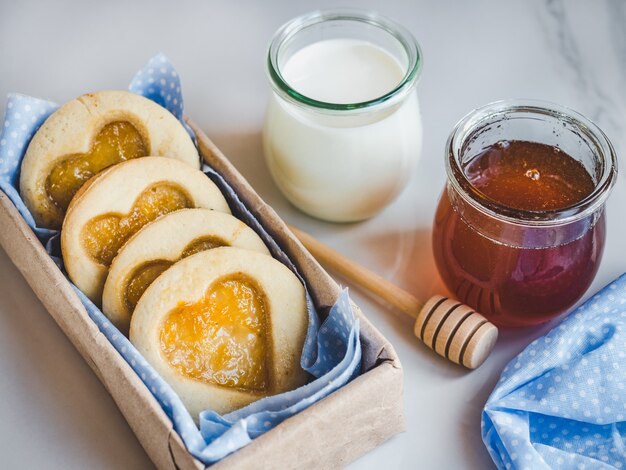 Biscoitos frescos, copo de leite e jarra