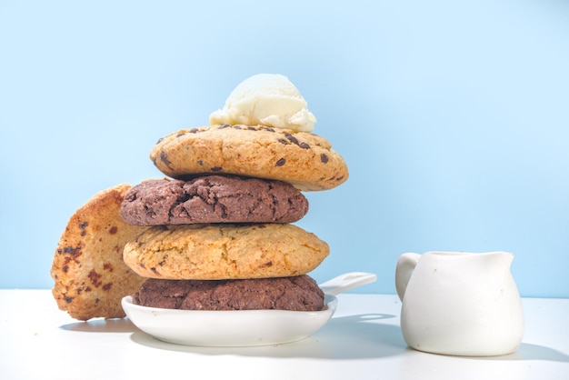 Biscoitos gigantes de chocolate e branco. biscoitos bem grandes - chocolate, baunilha, raspas de chocolate, com bola de sorvete. cozimento doce moderno.