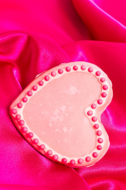 Biscoitos Gourtmet em forma de coração decorados para o Dia dos Namorados em seda rosa.